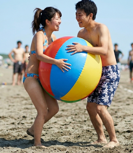 bbf_man's tweet photo. AIで作った架空の大学のサークルの夏合宿での一コマです。ビーチボールサークルという、ビーチバレーをするわけではなく、ビーチボールを使ったレクリエーションをするサークルのようです！女子学生の多くがビーチボールを持ってきて、男子学生とペアになりビーチボール挟みゲームをしています。 https://t.co/TLkDGdUUko