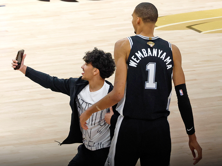 TMZ's tweet photo. A fan storms the court for a selfie with Victor Wembanyama during the NBA Finals game 1. 

Video: https://t.co/XMt7feUMux https://t.co/5S0rJzrMex
