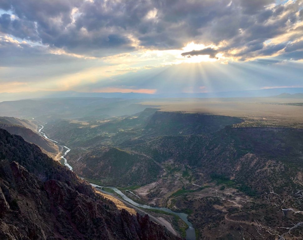 This is the Río Grande del Norte National Monument in northern New Mexico.Specifically, the image captures the Rio Grande Gorge, a deep canyon carved by the Rio Grande through volcanic basalt flows on the Taos Plateau.