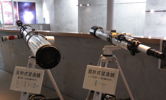 tenmon10's tweet photo. 【展示コーナーに2つの望遠鏡】
反射望遠鏡と屈折望遠鏡です！望遠鏡は光を集め、遠くの星を見ます。
光を集めるのに反射望遠鏡では鏡を、屈折望遠鏡ではレンズを使用しています。
館内に展示してあるバラ星雲とオリオン大星雲のパネルがどのように見えるか、覗いてみてください！ https://t.co/EVTOh6s7x9