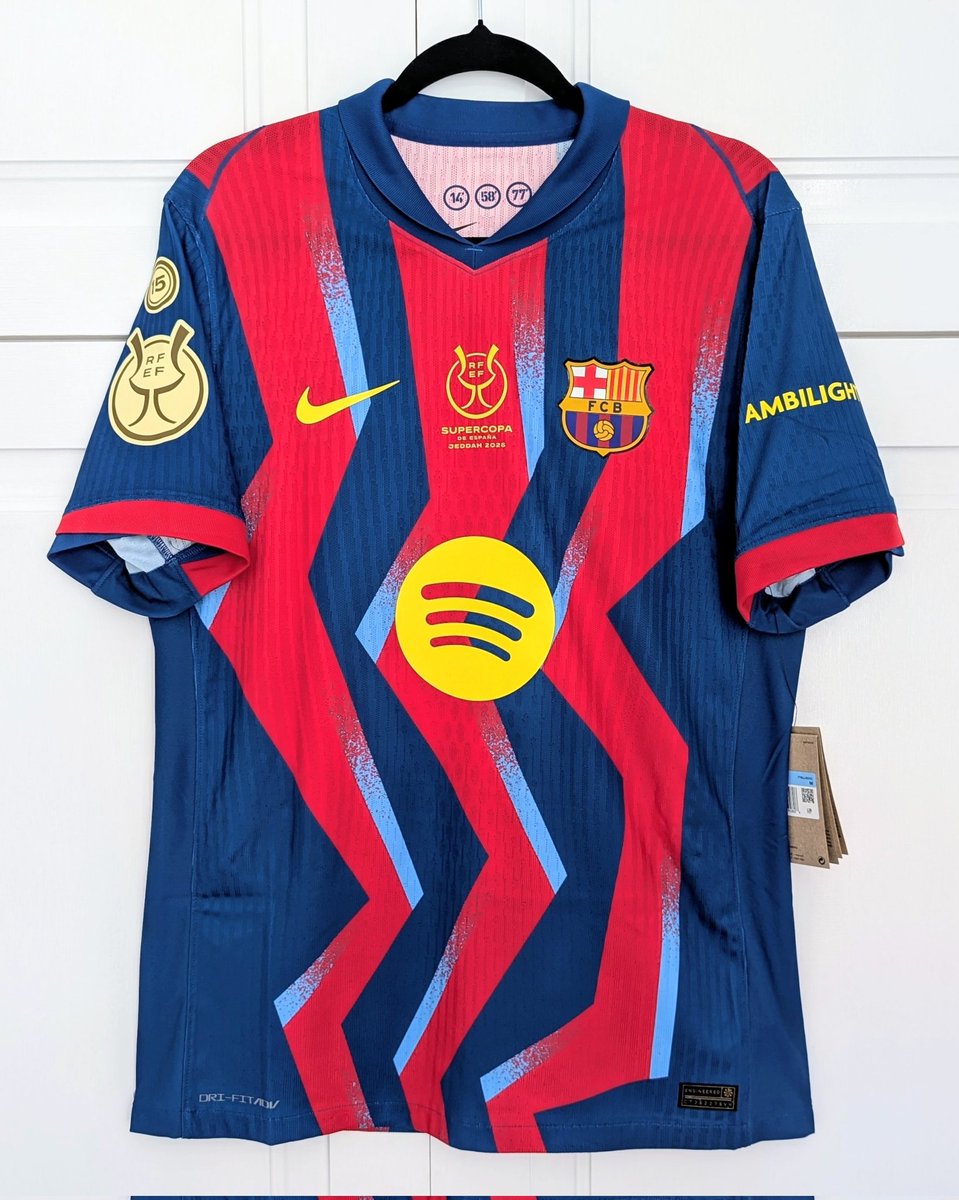 polyester_fever's tweet photo. I held off on release, but after it came in the sale I couldn't resist. With full Super Copa detailing and nameset for skipper Raphinha, it's a fantastic shirt. Raphinha scored twice as Barca overcame Real 3-2 in Saudi Arabia. I love the detailing on this shirt, and the zig zagged graphic design apparently paying tribute to the endless passion and energy of the club, as well as the routes taken by Ronaldinho and Eto'o towards goal in their famous 3-0 win over Real back in 2005. The timing of each goal is printed inside the collar. It's been said before, should have been the home shirt.