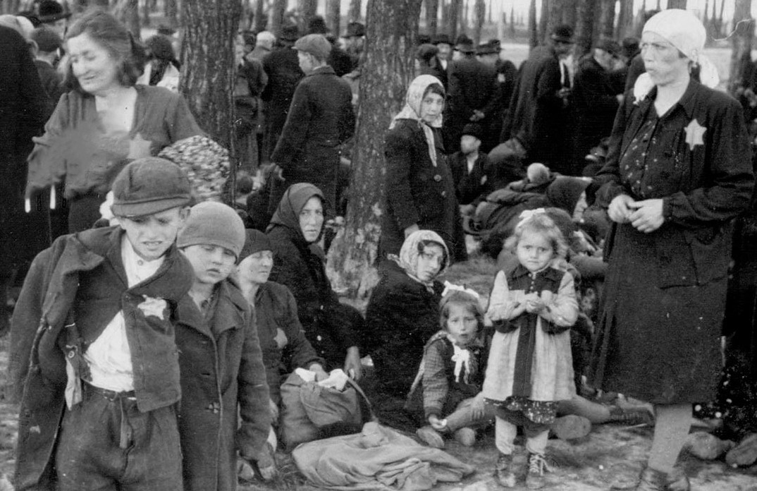 RabbiPoupko's tweet photo. What are these women and children waiting for?

They are in line for the gas chambers in Auschwitz. 

On the ONE DAY of June 3rd, 1944, four transport trains carrying  12,000 Hungarian Jews arrived at Auschwitz, and the gas chambers were overwhelmed.
 
Even the world's largest death factory and industrialized murder machine could not hold the volume of Jews Adolf Eichmann was sending it, so some were asked to wait in the forest nearby.

More than 437,000 Hungarian Jews were deported to Auschwitz in just 56 days, moments before the war was over.  

We will never forget.
