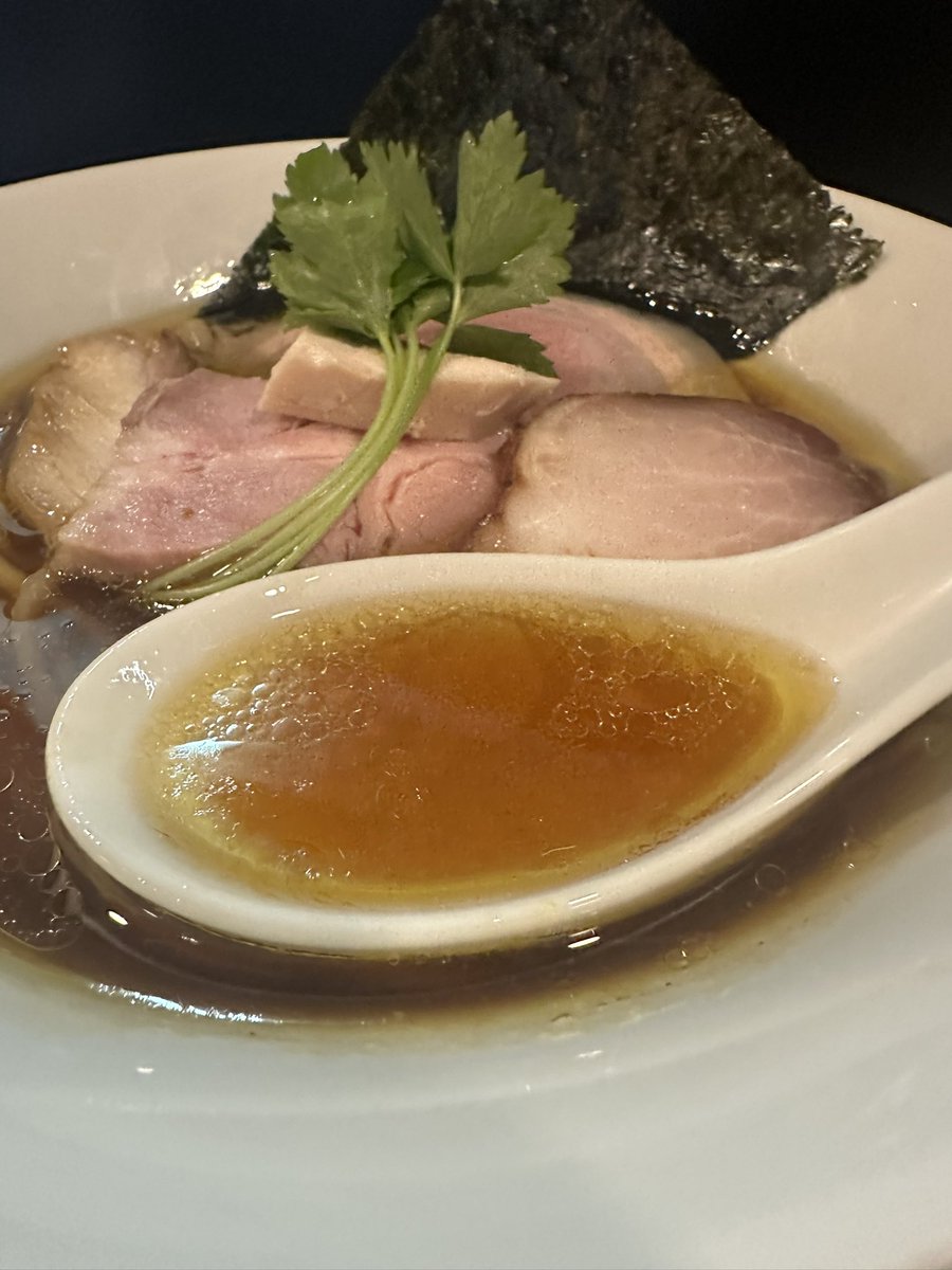 senjusan's tweet photo. らぁ麺飛鶏
地鶏の生揚げ醤油そば
この日は病院に行ってからの来店のため13時頃来店すると想像以上の大賑わい😅
告知もないこんな平日の水曜日に何かあるのかなぁ😁
週末並みに知り合いに会うんだが皆んなちゃんと仕事してるんだろうか？😎笑
やっとの思いで入店するとつけそば2種類とこの日の限定濃厚地鶏白湯まで全て売り切れ🥲
でもこんな時しかなかなかポチれない''鶏そば''があるからノープロブレムだけど😏
流石フラッグシップである地鶏の生揚げ醤油そば✨
美しく優雅な佇まいから想像できない奥行きのある野趣に富んだ香りとコク深く力強い味わい🤤
地鶏の旨みに金華豚の深みが調和をとり生揚げ醤油の濃厚なキレが絶妙なまでに重なりチョーゼツ美味いがね〜😭
ひと口スープを飲んでみるとまずはブワッとした醤油の香りが口いっぱいに広がり遅れて香ばしさと仄かな甘味を含んだ鶏の旨みが舌全体に馴染んでくる☺️
麺も変わってるように感じたがどうだろうか？🤔
限定ばかり食べてるからアテにならない記憶だからなぁ🫣笑
以前より加水率が上がり？よりもっちりとした平打ち麺の食感が堪らなく心地いいね😋
調理法の違う多種多様のチャーシューのクオリティは言わずもがな特に例の神豚はマジでえぐい🤣
''醤油''が美味しいお店は他にも沢山あるけれど僕を心の底から満足させる醤油ラーメンは飛鶏さんと新宿にあるあのお店くらい😙
まあ満足したらそこで''試合終了''
なんで長谷川さんには更なる進化を目指して限界の向こう側を見せてもらいたいけど🤭
満足しねぇ奴こそ強くなれるし上手くなれるんだよ！と自分の言葉に酔いしれながらやっぱり今日も控えめに言って宇宙一でした😂