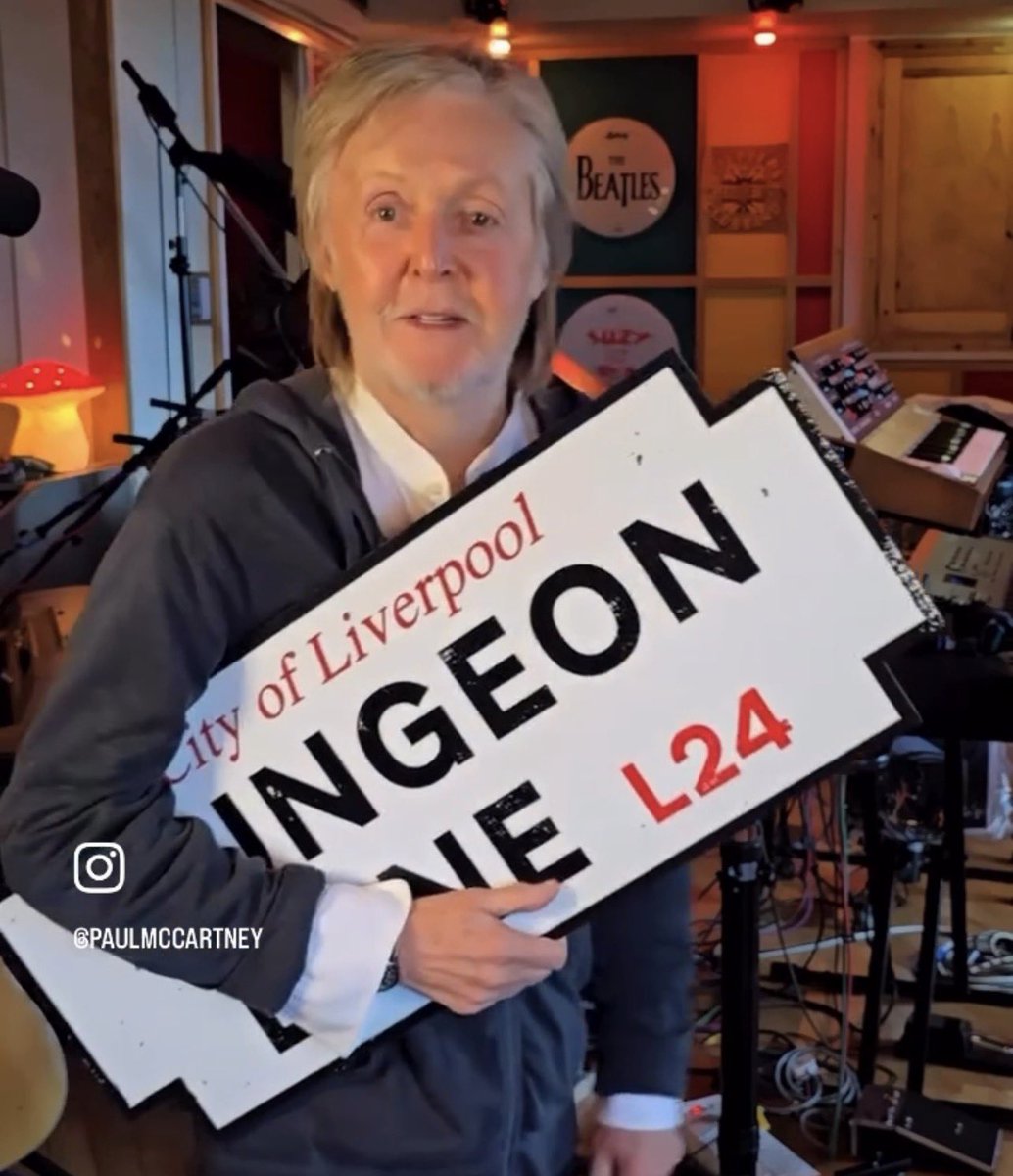 peterlanee's tweet photo. How lovely to see Paul in his little studio holding the Dungeon Lane sign with the drumheads of The Beatles and Suzy and the Red Stripes in the background https://t.co/blnxGalSmU