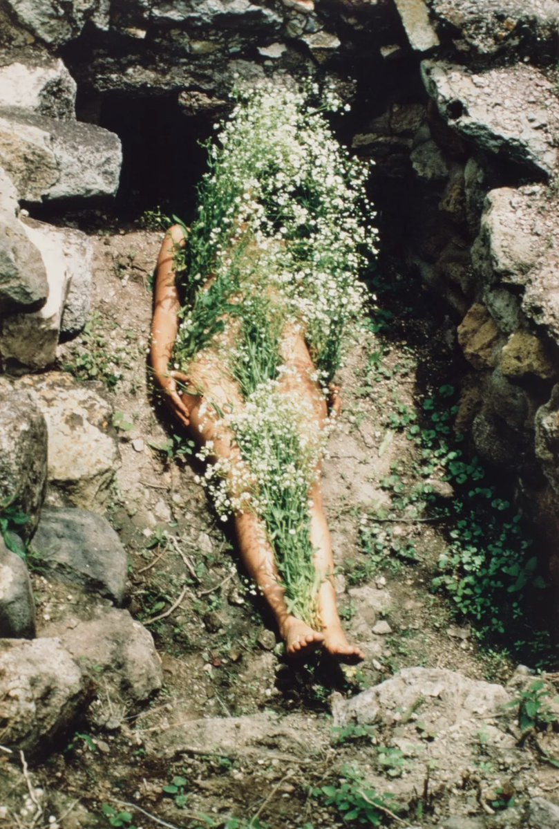 OrderGoodDeath's tweet photo. In artist Ana Mendieta’s Silueta Series, she pressed, carved, or traced the outline of her body into soil, sand, grass, and stone. Sometimes filled with flowers, fire, or water, these forms were never permanent. They eventually faded, were washed away, or burned out. https://t.co/P3T7V4UdCn