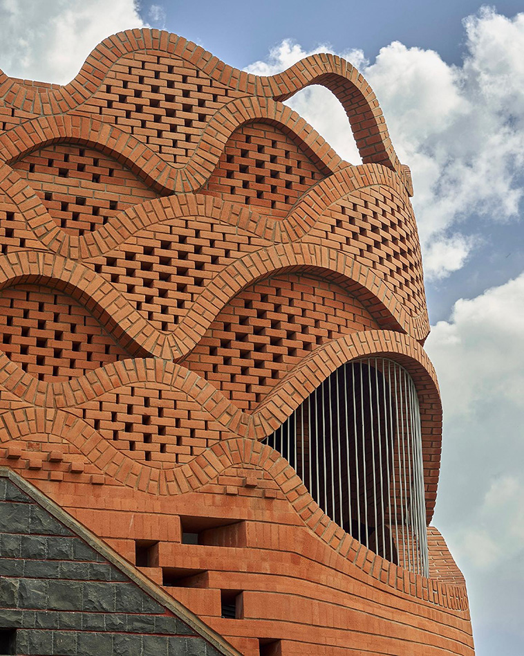 archpng's tweet photo. Brick, but treated almost like fabric.

Gadi House by PMA madhushala reinterprets the regional “gadi” — a small fortress-like home — with thick protective walls, inward courtyards, and layered thresholds.

Its most striking detail is the upper brick crown: a wave-like, perforated skin that filters light and air while giving the house a sculptural silhouette.
