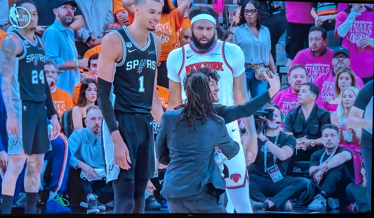 OnlyRealLeft's tweet photo. A crazed fan rushed the court during Game 1 of the Finals between the Spurs and Knicks-just for a selfie. Wemby smiles, while Mitchell Robinson looked annoyed. 😅 https://t.co/Zex6RKYrTb