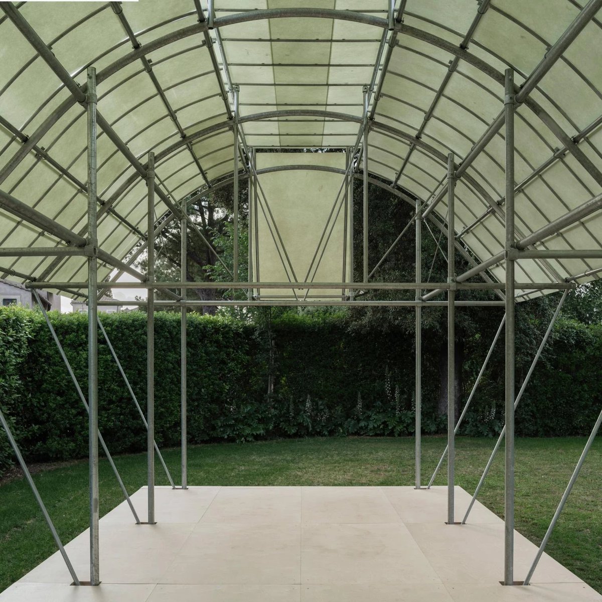 arquitect_viva's tweet photo. Pabellón Cabane 7L en la Villa Medici. Roma
Salazar Sequero Medina
https://t.co/P80ebOrlYS
El pabellón forma parte de las seis intervenciones de la quinta edición del Festival des Cabanes arquitectónicas que pueden visitarse hasta el 28 de septiembre en los jardines De la Villa Medici, y propone una reinterpretación contemporánea de las antiguas pérgolas renacentistas.
El pabellón se integra en el paisaje gracias a su estructura ligera y permeable, de acero, fibra de vidrio y madera de pino. Su diseño recupera la visión de las pérgolas representadas por Jacopo Zucchi en los frescos de la Stanza degli Uccelli (Sala de los Pájaros) de la Villa Medici, realizados entre 1576 y 1577. En estas pinturas, Zucchi creó una ilusión óptica con un enrejado, evocando las arquitecturas ligeras utilizadas por los Medici para proteger limoneros y especies exóticas.