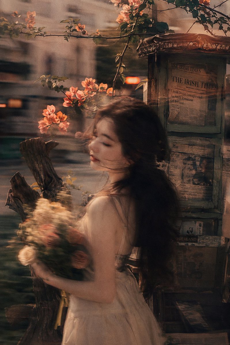 MissDelulu9's tweet photo. Made with ChatGPT 

Prompt:

Using the person in the uploaded photo as the reference, vintage film photography with visible film grain, realistic lighting and shadows, retro color tones, and a Fuji-style filter. Beside an old newspaper kiosk lies a piece of deadwood, with blooming orange-pink flowers nearby. Interwoven vintage film grain textures, a blurred background with lingering motion trails, and a double-exposure effect create a strong surreal atmosphere.

A captivating young woman holds flowers in a side pose, with cool fair skin that appears delicate and translucent. Her refined facial features carry a sense of motion blur, while her silhouette gently sways with the movement of a panning camera. Warm-toned, low-saturation filtering enhances the mood. Her long hair glows softly under backlighting, shimmering with natural radiance, while loose strands sweep quickly across her jawline in the wind. She exudes an alluring blend of sweetness and danger, with cute, lively gestures that bring energy to the scene. Motion blur merges seamlessly with the film grain, creating both a trendy social-media aesthetic and a rich storytelling atmosphere, perfectly balancing seductive charm and sweetness. The facial appearance should be adjusted to harmonize naturally with the overall image.