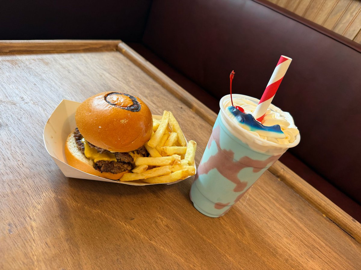 insideuniversal's tweet photo. 2 new Jaws items have been added to the Richter’s menu for the Summer:

WE'RE GONNA NEED A BIGGER BOAT:

3 smash patties, American cheese, grilled onions, secret sauce, pickles, on a Jaws-branded brioche bun. 🦈 

SHAKE ATTACK:

Tropical Blue Shake (pineapple, orange & coconut) finished with a strawberry “chomp” splash and topped with gummy shark. 

@UniversalORL