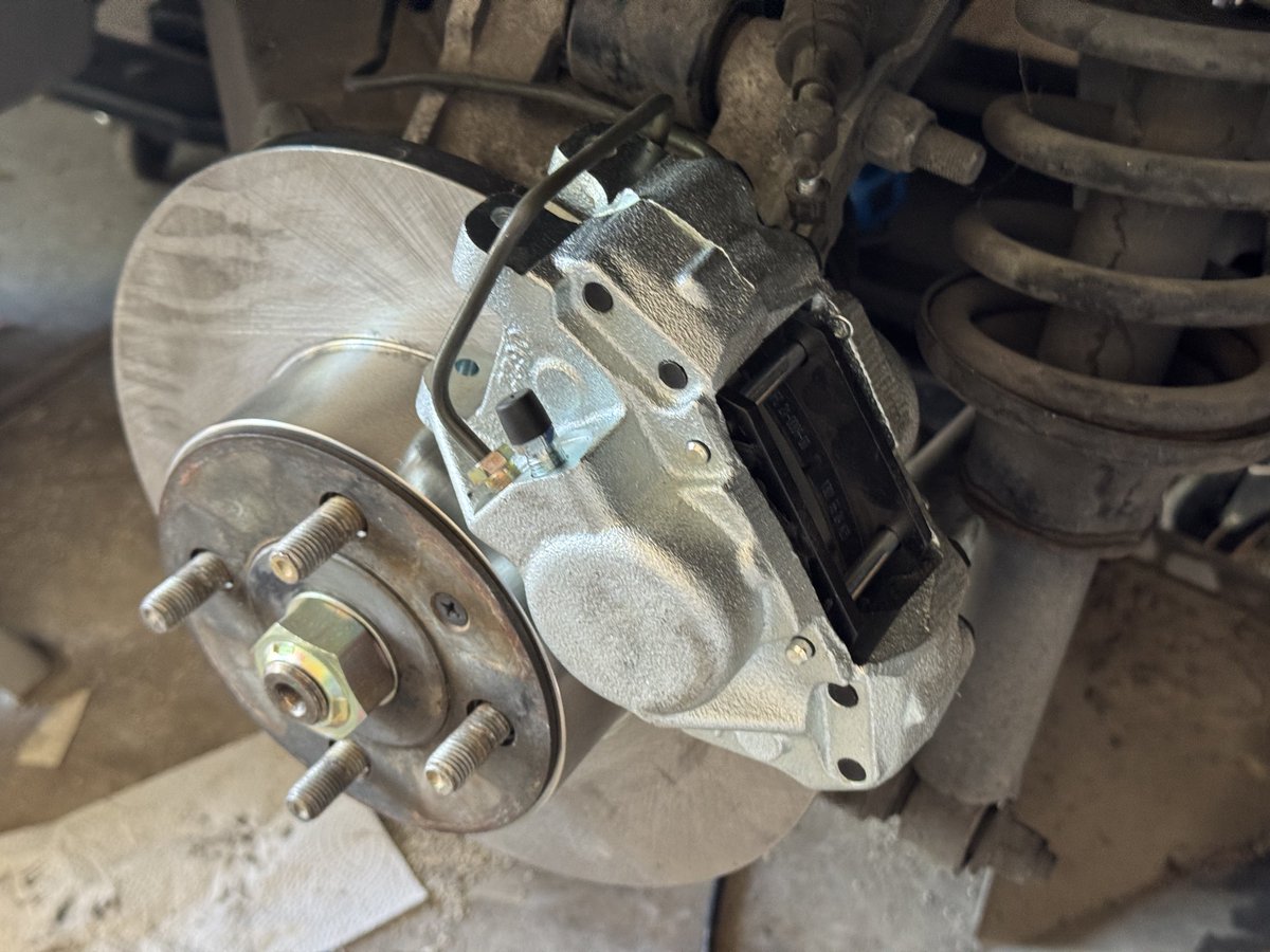 michaeljaygates's tweet photo. Shiny new rear rotors and calipers on and torqued to spec! Finally getting to work on the car again after almost a month of being sick. Next, front calipers, master cylinder, and then the final brake bleed. Biggest hurdle is that the new driver side caliper is too narrow, so I have to file down the pads a whole bunch to fit.