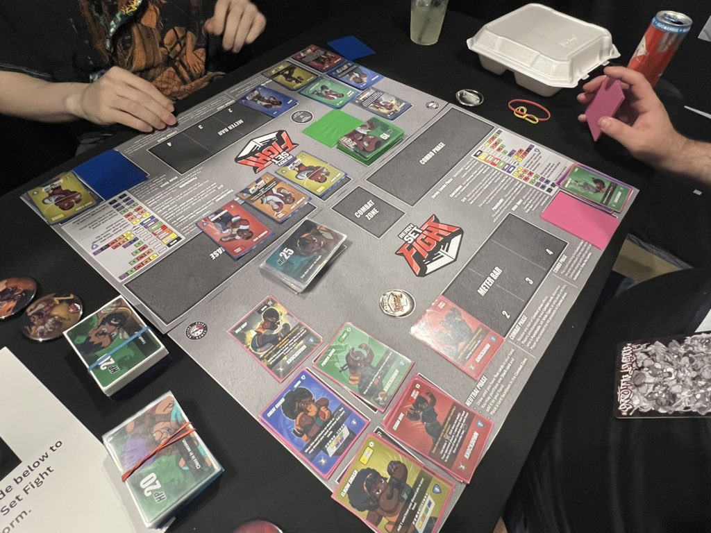 jchensor's tweet photo. I meant to Tweet out yesterday that o had a chance to stop by the Ready Set Fight exhibition table at Combo Breaker.

It’s a card game that is trying to replicate the feel of a Fighting Game, and I encourage everyone at Combo Breaker to stop by and give it a try. It’s pretty fantastic. It’s right next to the main command center table in the main exhibition hall.

I only played one game and one character, but the potential seems so high for new characters and really cool variety and ways to take advantage of the mechanics. I played the Grappler, of course. 😏

Unlike most Card Games, it’s not a collection pay-to-win game. It’s just more characters being released. And it’s very much a mental game and reading opponents with very little RNG because I even won my first game against the creator and got a souvenir Token as a prize! ^_^

So I do encourage people to stop by and try the game out at Combo Breaker if you can!