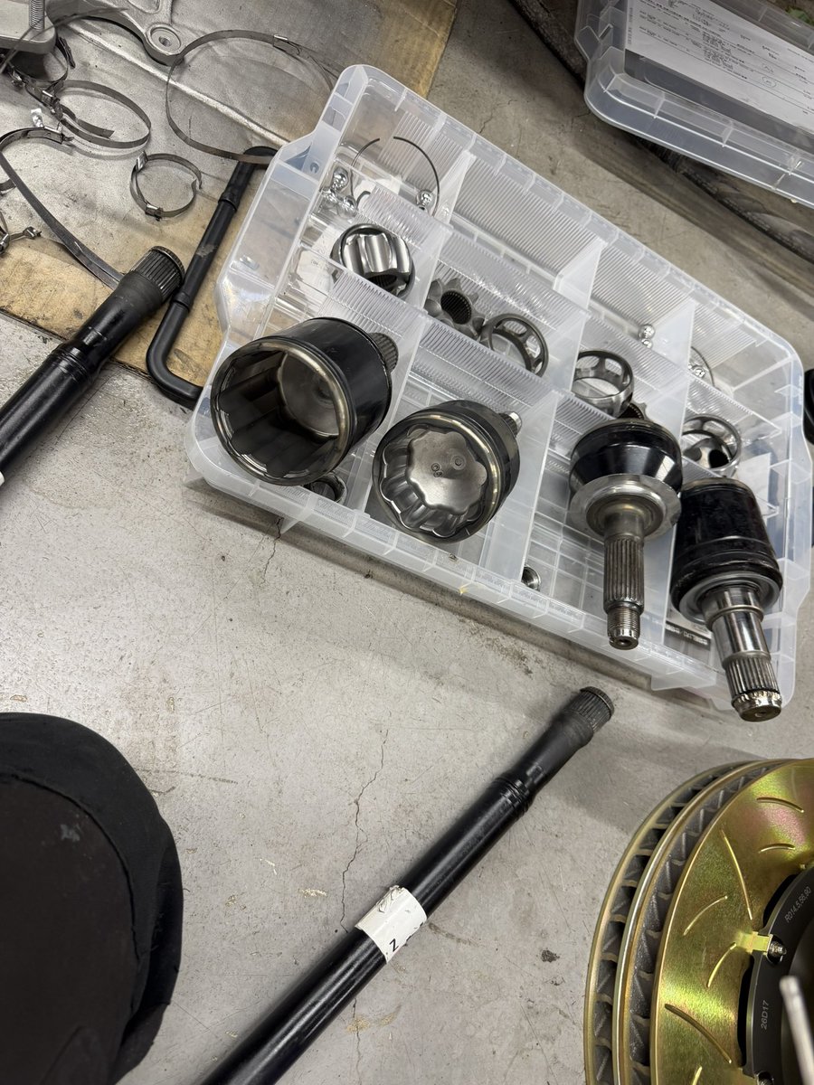 TiRacingtir's tweet photo. 【GR86 ドライブシャフト整備】⑤

GR86のリアドライブシャフトOH作業、
ドライブシャフトブーツの装着。

GR86のリアドライブシャフトは、
アウター側が非分解構造となっているため、
純正ではブーツ単体での供給設定がありません。

そのため一般的には、
洗浄後に再利用されるケースも多く見受けられます。
バンドは汎用幅狭タイプを使っていたりしてる場合もあります。

TiRACINGでは、
インナー側には純正新品ブーツ、
アウター側には高耐久仕様の5山ブーツを採用しております。

ではなぜ、
GR86ドライブシャフトブーツの
「再利用」を推奨していないのか。

その理由は、
樹脂ブーツ特有の
「熱」と「内圧」による永久変形にあります。

樹脂ブーツは新品時、
金属溝へ強い面圧で密着するよう設計されています。

しかしサーキット走行では、

・高温
・高回転
・遠心力
・内圧上昇

といった過酷な条件が繰り返されることで、
締結された状態のまま
樹脂が徐々に変形・劣化していきます。

外観上に破損が見られなくても、
一度バンドを取り外した時点で、
新品時と同等の密着面圧を再現することは極めて困難です。

街乗りでは問題が発生しなくとも、
サーキットにおける超高速回転域では、
わずかな密着差からグリス漏れが発生するリスクがあります。

特にインナー側は、
ストローク量が大きく、
熱や繰り返し変形による疲労が蓄積しやすい箇所です。

そのためTiRACINGでは、
サーキット走行車両において、
ブーツの再利用を基本的に推奨しておりません。

Ωバンドの締結にはエアピンサーを使用し、
締結面圧にも十分配慮したうえで組み付けを行っております。

締め付けが強過ぎても不適切であり、
逆に弱過ぎても性能を十分に発揮できません。

特に樹脂ブーツは、
適正な面圧で均一に締結することが非常に重要です。

単に
「修理書に再利用不可と記載されていないから再利用する」
という考え方ではなく、

極限領域で発生し得るリスクを事前に排除する。

その積み重ねこそが、
サーキット走行における安心感へと繋がると考えております。

#GR86
#ドライブシャフト
#CVジョイント
#TiRACING
#結果が全て