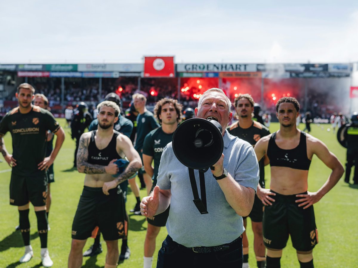 slabak2's tweet photo. #ajautr wat een prachtige maar tevens bizarre foto is dit zeg. Een stralende Jans, balende selectie tegen de achtergrond van een linie ME en feestvierende Ajacieden. En dat allemaal in een finale onwaardig stadion. 

25/26 wat was je lang(52x), boeiend maar ook vaak net niet. 🙏 https://t.co/40sNvH7mNy