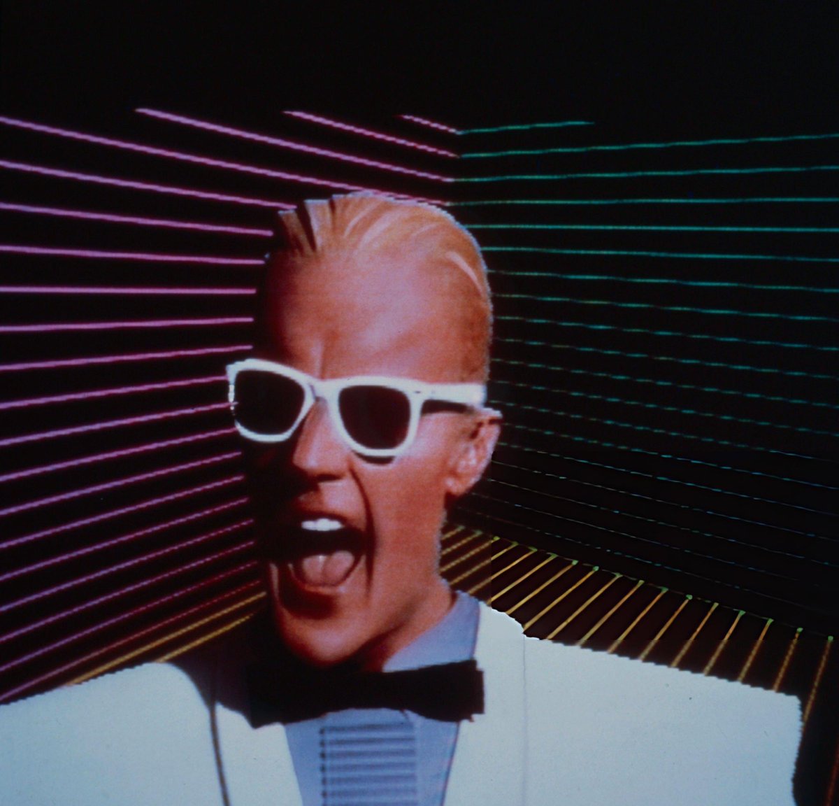 AyerNomasSeries's tweet photo. La imagen de #MaxHeadroom no era generada por computadora. El actor Matt Frewer usaba una prótesis de maquillaje compleja superpuesta mediante tecnología de pantalla azul. Los "ticks" se crearon repitiendo un solo fotograma varias veces. https://t.co/TtgJC0pd6F
