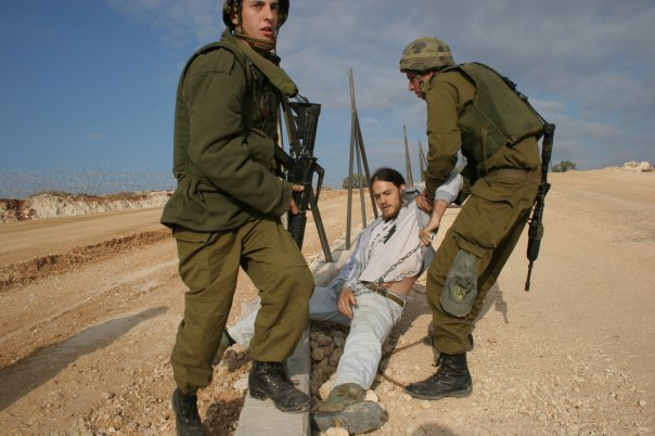 ireallyhateyou's tweet photo. Here's me at age 19, during a direct action against the building of the Apartheid Wall in Bil'in, West Bank. First photo is a screenshot from the the movie "5 Broken Cameras". The second one is of my arrest, a few minutes later. https://t.co/gTh9vYMzLY