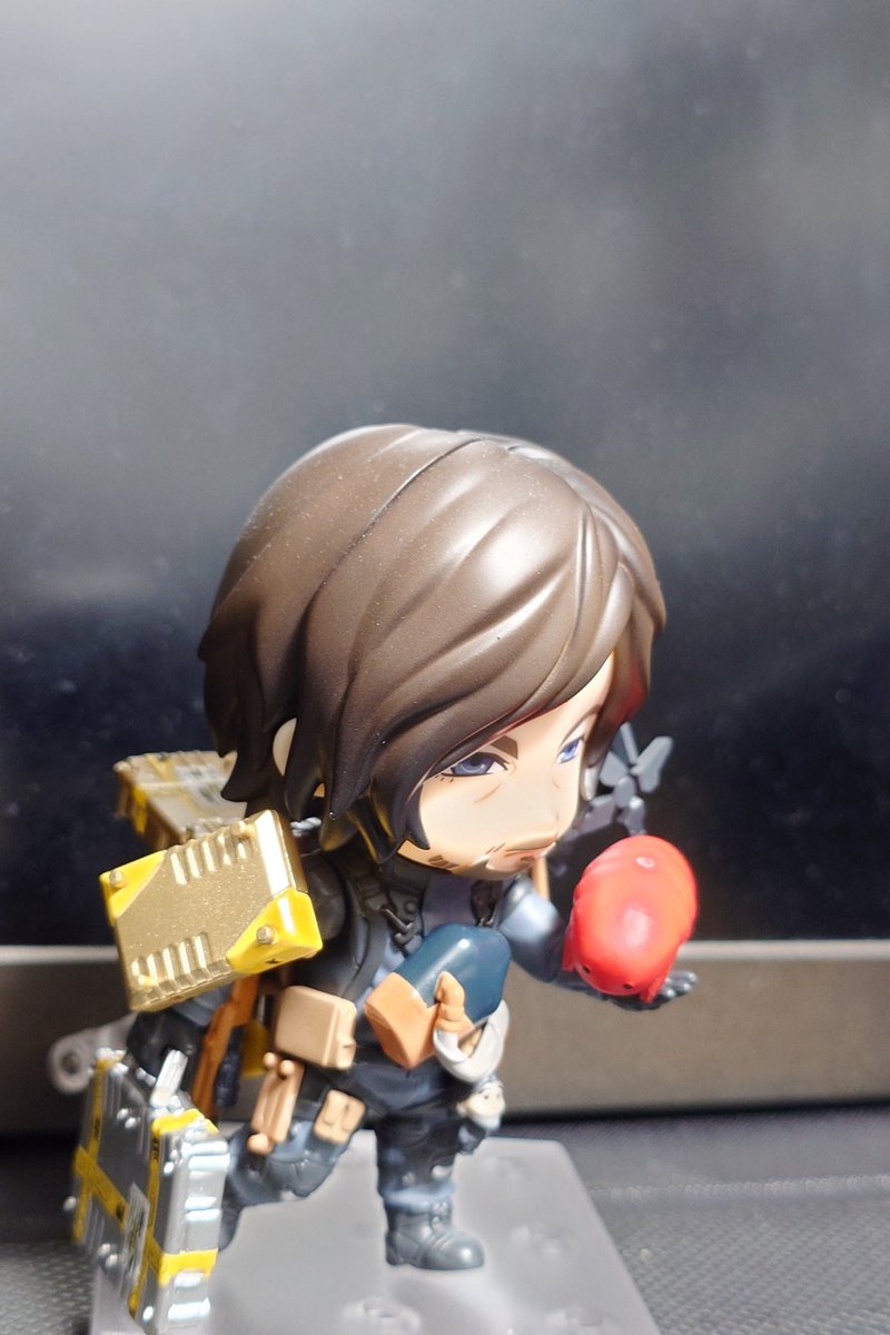 Mr_Yesterday's tweet photo. 「食べながら配送中」

ガチャポンでゲットしたアイテムをねんどろいどサムに届けてみた🎵

違和感なく、荷物（ゴールド＆シルバー）とクリプトビオシス（メキシコ）を配置できた💕
（チェーンの部分外してます）

#DeathStranding2OnTheBeach 
#DeathStranding2
#デススト2
#BANDAINAMCO 
#ガシャポン https://t.co/8HP1KjxSwI