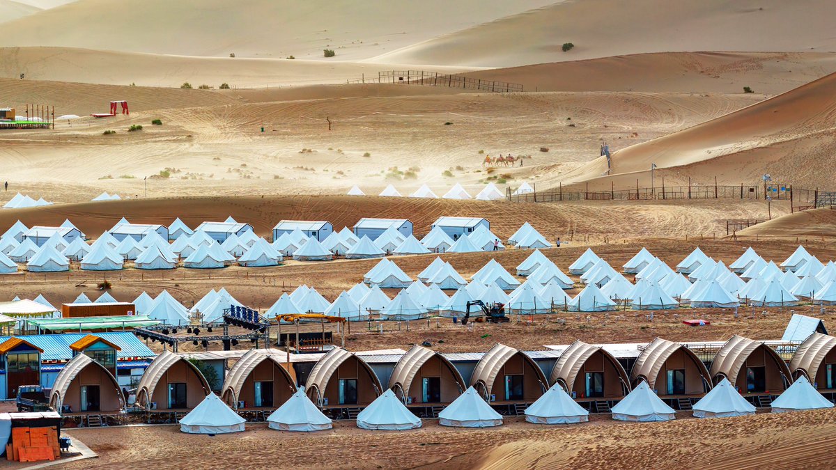EDNewsChina's tweet photo. Aerial footage presents the grand scale and distinctive scenery of Crescent Bay International Desert Camping Base in Dunhuang City, China's Gansu Province. https://t.co/RQ3Y4v7Z3W