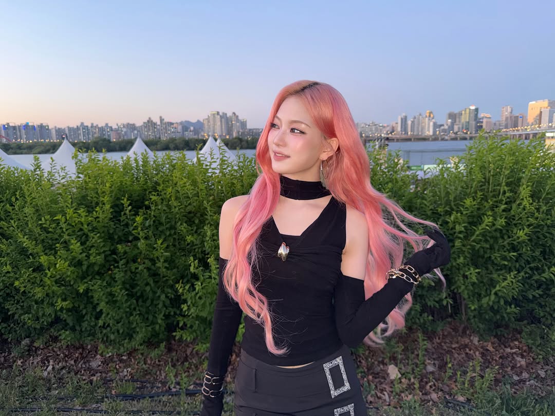 chaelyisa_'s tweet photo. the perfect contrast: all-black outfit, cotton candy-colored hair, and the city lights in the background. very beautiful  🖤🩷 https://t.co/nllW8PEayX