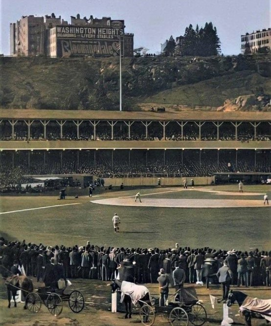 Jimfrombaseball's tweet photo. "Like the team itself, the Polo Grounds is an absurd and lovely thing.
It is the only ball park built against a cliff, "Coogan’s Bluff", so that a patron could walk downhill to his seat.
It had a crazy name and crazy dimensions. In shape, it was closer to a bowling alley than a ball field.
Straightaway sluggers loathed the field because a really noble smash to center, good for a homer in any other park, only amounted to a loud and discouraging out.
I liked it best when we came into the place from up top, rather than through the gates down at the foot of the lower-right-field stand.
You reached the upper-deck turnstiles by walking down a steep, short ramp from the Speedway, the broad avenue that swept down from Coogan’s Bluff and along the Harlem River, and once you got inside, the long ﬁeld within the horseshoe of decked stands seemed to stretch away forever below you, toward the bleachers and the clubhouse pavilion in center.
Everything about the Polo Grounds was special, right down to the looped iron chains that separated each sector of box seats from its neighbour and could burn your bare arm on a summer afternoon if you weren’t careful.
Far along each outfield wall, a sloping mini-roof projected outward, imparting a thin wedge of shadow for the bullpen crews sitting there:
They looked like cows sheltering beside a pasture shed in August."
Roger Angell.
"The Polo Grounds."