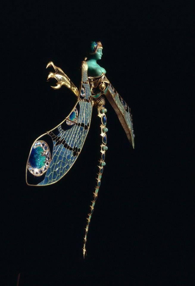 Desailaur's tweet photo. Entre el oro y el sueño, una mujer se convierte en libélula.  Alas translúcidas de esmalte capturan la luz como aliento de hadas. Crisoprasa verde, diamantes y piedras de luna envuelven su rostro en un susurro de metamorfosis. Una criatura de puro Art Nouveau. #MuseuGulbenkian https://t.co/iABU4TWbhv