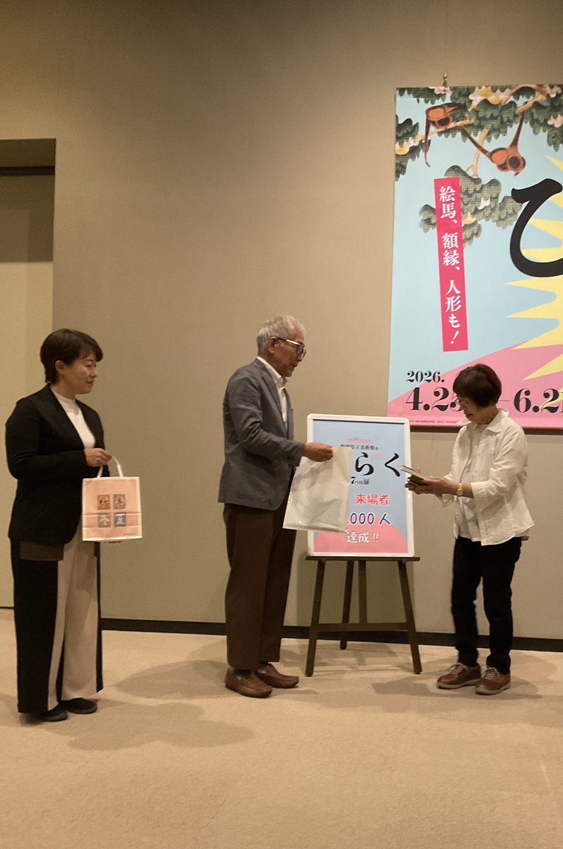 shizuokakenbi's tweet photo. #静岡県立美術館 で開催中の開館40周年記念展「#静岡県立美術館をひらく　７つの扉」の観覧者が、本日、１万人目を達成しました🎉
１万人目のお客様は、静岡市内からお越しの高田様です。木下直之館長から図録などの記念品が贈られました💐
会期は6／21(日)までです。
ご来館をお待ちしております。 https://t.co/TUaJk0wztb