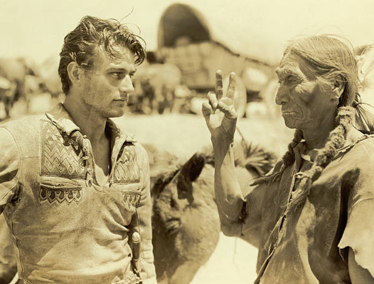 ClassicMovieDig's tweet photo. Birthday Remembrance for John Wayne.  Here 23-year-old Wayne is photographed with a Crow Indian in Wyoming during filming of "The Big Trail" (1930).
#BOTD https://t.co/Ny1Btu0ihB