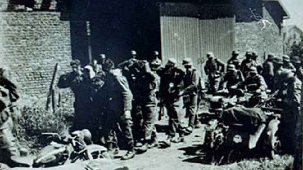 JenKteach's tweet photo. Remembering the 27th May 1940: The Le Paradis Massacre and all those who lost their lives

During the Battle of France, as British Expeditionary Force (BEF) troops fought desperate rear-guard actions to enable the evacuation from Dunkirk, members of the 14th Company, SS Division Totenkopf (under Hauptsturmführer Fritz Knöchlein) committed a war crime in the hamlet of Le Paradis, near Lestrem in the Pas-de-Calais region of northern France. 

Soldiers from the 2nd Battalion, The Royal Norfolk Regiment (with some from the 1st Battalion, The Royal Scots and other BEF units) became isolated while holding a defensive line. They occupied and fiercely defended Cornet Farm (also referred to as a farmhouse or barn area) against repeated German attacks involving mortars, artillery, tanks, and infantry. 

After running out of ammunition around 17:15, the defenders (approximately 99 men, many wounded) surrendered under a white flag, led by Major Lisle Ryder. They were disarmed, marched a short distance across the road to a barn wall/paddock area on a nearby farm, lined up, and murdered by machine-gun fire from two heavy machine guns. SS troops then used bayonets and pistols to finish off any apparent survivors. 

97 British soldiers were killed. The Germans forced local French civilians to bury the bodies in a shallow mass grave the next day. 

Two men; Private William "Bill" O'Callaghan (from Dereham, Norfolk) and Private Albert "Bert" Pooley (from Southall, London) survived their wounds by feigning death, hiding among the bodies, and later in a pigsty for three days. They were aided by brave French civilians (Madame Duquenne-Creton and her son Victor) before being recaptured by regular German Army troops (251st Infantry Division) and taken to hospital. Their accounts were initially met with scepticism in Britain but were later corroborated.

After the war, Knöchlein (by then an Obersturmbannführer) was tracked down, tried by a British military court in Hamburg in 1948, and convicted on the testimony of the two survivors and other evidence. He was sentenced to death and hanged on the 21st January 1949 in Hamelin Prison. No other German personnel were prosecuted for the massacre. 

We Will Remember Them.
"𝕲𝖗𝖊𝖆𝖙𝖊𝖗 𝖑𝖔𝖛𝖊 𝖍𝖆𝖙𝖍 𝖓𝖔 𝖒𝖆𝖓 𝖙𝖍𝖆𝖓 𝖙𝖍𝖎𝖘, 𝖙𝖍𝖆𝖙 𝖆 𝖒𝖆𝖓 𝖑𝖆𝖞 𝖉𝖔𝖜𝖓 𝖍𝖎𝖘 𝖑𝖎𝖋𝖊 𝖋𝖔𝖗 𝖍𝖎𝖘 𝖋𝖗𝖎𝖊𝖓𝖉𝖘."
#WeWillRememberThem #LestWeForget