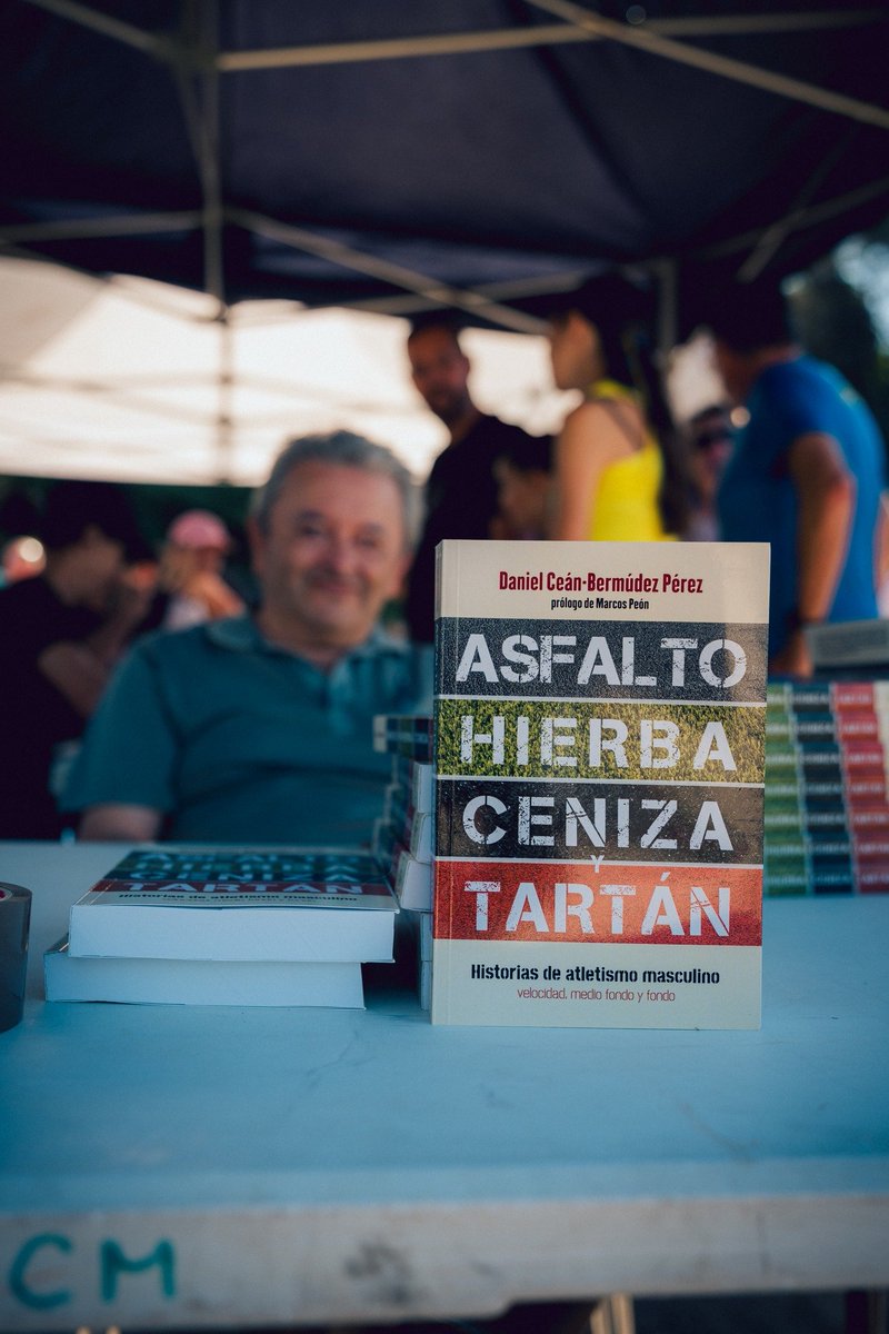 Daniel_Cean's tweet photo. 'Ceniza' en el foco, el libro 📙 en primer plano y el autor sonriente al fondo. Así captó📸 @vsmphotoevents nuestra presencia con 'Asfalto, hierba, ceniza y tartán'  en el Memorial de Atletismo @QuadraRuta de la @APCeniza https://t.co/eBMKo8wrnv