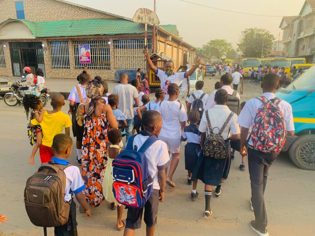 SNVRDC's tweet photo. Inspiré par la culture du volontariat londonien, Jules KIAKU a choisi de servir sa communauté après son retour à Kinshasa.
Chaque matin, midi et soir, il aide bénévolement des élèves à traverser le boulevard en toute sécurité. Un geste simple, un impact immense🇨🇩#Volontariat #RDC https://t.co/oUVNrwFPmj