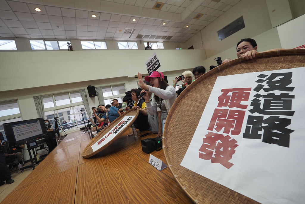 eventsinfocustw's tweet photo. 【名間焚化爐》聯外道路爭議　南投環保局：通過環評再說】

圖／文：王子豪

南投縣政府環保局5月27日召開名間焚化爐二階環評範疇界定會議，「名間鄉反焚化爐自救會」提出水利署第四河川分署的回函，質疑該計畫沒有既有的聯外道路，並將必要的道路開發，切割於環評範圍之外。南投環保局表示，等到通過環評再說。

依據南投環保局的初步規劃，未來名間焚化廠的主要聯外道路是「新民巷」。這條「新民巷」實際上是水利署第四河川分署的水防道路，依據環保局的說法，目前路寬約2公尺，後續要至少拓寬為8公尺、並申請作為一般道路使用，才能符合《非都市土地開發審議作業規範》的要求（該規範規定聯絡道路應至少有獨立兩條，主要道路路寬至少須達8公尺以上）。

但這條有拓寬必要的道路，卻不在目前的環評範圍中。而且，南投縣環保局已進行了新民巷拓寬工程的招標決標，遭質疑違反環評法。第四河川分署的回函則表示「濁水堤防水防道路，並非既成道路」，而對於南投縣政府擬申請作為聯外道路，表示「於該開發案未取得環評通過證明文件前，本分署暫不予受理該段水防道路之相關使用申請」。

名間鄉鄉長陳翰立表示，依據環保局的規劃，清運車輛會從新民巷接名竹大橋，這段路線現在有砂石車、豬車，都已經造成很大的環境影響。另外，每年春節到土地公生日這段期間，從名間交流道、名竹大橋、到竹山紫南宮這一段路都很塞。環保局之前說「保證每天有500噸垃圾可燒」，陳翰立質問環保局未來會增加的垃圾車數量？環保局回應，垃圾車有大有小，還沒評估換算的車輛數量。

地方居民表示，焚化爐有規劃一條次要道路，是往北方的外埔巷。外埔巷會經過外埔聚落，聚落內道路狹窄，質疑根本無法供垃圾車通行，容易造成車禍事故，或未來外埔可能遇到土地徵收來拓寬道路。會議主席陳谷汎一度回嘴「所以你們是要拓寬、還是不拓寬」？讓居民一陣錯愕，不知如何替開發單位回應開發規劃內容。環保局最後承諾，次要道路只會供消防、或緊急通行。但居民對於只靠主要聯外道路，來消化每天500噸的垃圾運量的說法，仍抱持懷疑。

〈名間焚化爐》聯外道路爭議　南投環保局：通過環評再說〉
全文：https://t.co/rG5Vt5p2HO

《焦點事件》時時自問「媒體該做的事是什麼？」，並致力於乏人問津的媒體「基礎建設」工作，這些工作哪怕只是往前走一點點，都非常困難（也因此就乏人問津），它需要你的支持：
🌐發票捐贈愛心碼：1968
🌐月定捐（信用卡）、單筆（信用卡及超商、webATM）
　　🔗https://t.co/O3cYO5pVrq
🌐郵政劃撥：
　　➡帳號50363139
　　➡戶名台灣焦點通訊社