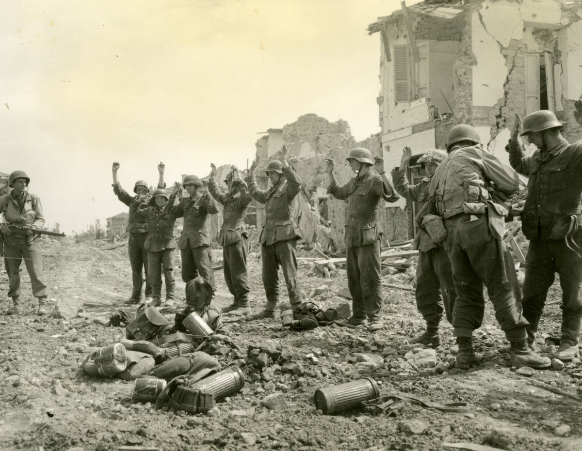 WWIImuseum's tweet photo. In this image from our Digital Collections taken May 27, 1944, German soldiers raise their hands in surrender to US troops in Cisterna, Italy. #OnThisDay https://t.co/NGDiGf9EUv