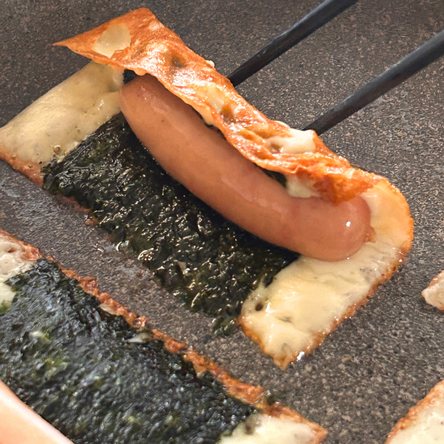 marudai_wanpaku's tweet photo. 鉄板でチーズをこんがり焼いて、海苔と燻製屋熟成ウインナーをのせてクルッと巻く。おうちなのに、気分は完全にキャンプ。パリッと弾けて、じゅわっとうまい。そこにふわっと広がる燻製の香りまできたら、もう止まりません。お酒のお供にもピッタリ。今日はもう何も考えずにこれだけ食べて寝ましょう。 https://t.co/RLaXOMvQMR