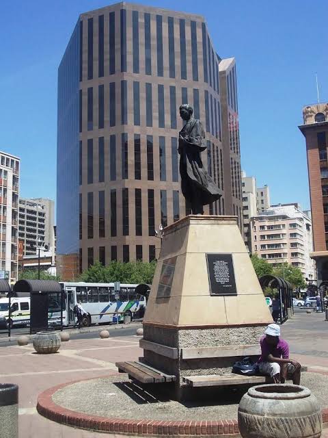 SizweLo's tweet photo. This is Gandhi Square in downtown Johannesburg.

It’s named after Mohandas K. Gandhi who in an open letter to the Natal Legislative Assembly, complained about how he felt Indians in the British Colony were being dragged down to the position of a “raw N****”.

Gandhi sailed all the way from India to southern Africa to show the British colonisers that Indians were so much better than Afeucans.

One of his earliest victories in Durban was petitioning the post office to open a third entrance so Indians would not have to share the entrance used by Blacks. 

And then when King Bambatha KaMancinza led an uprising against the British in 1905, Gandhi, the great pacifist volunteered the Indian community for it. Writing an Indian opinion in 1906, he said it was not for Indians to judge whether the Zulu revolt was justified. He was clear that the Indians’ existence in Natal depended on British power, and therefore it was their duty to help the British against the natives.

After the Boers arrested him for the campaign against the Transvaal Asiatic Amendment Act, Gandhi objected to being placed at the same level as the natives, whom he described as uncivilised, troublesome, very dirty and living like animals.

A year later, he wrote about spending a night in jail in great misery and fear because of a Chinese and an African prisoner who appeared to him to be “wild, murderous and given to immoral ways”. So, he petitioned the Bier Republic authorities for separate boarding, meals and bathrooms for Indian prisoners. Because, of course, he did.

Today, some people make excuses for Gandhi and claim that he later “repented” and “learned from his mistakes”.
But the thing is that four decades after he denigrated Africans in South Africa, the anti-colonial Indian Prime Minister Jawaharlal Nehru told him that Africans and Indians needed to stand together against the White regime in South Africa. Gandhi replied that however much one might sympathise with the Bantus, the Indians could not make common cause with them.

This was in 1939. This was AFTER Gandhi had already become celebrated internationally as a moral leader. By then he had developed his philosophy of “non-violence”, supposedly suffered enormously for Indian independence, and had every reason and opportunity to extend his principles universally. Yet, he still didn’t.

The defence that Gandhi simply didn’t know better collapses when you observe that people around him did know better and said so to his face. It’s insane to imply nobody in that era could have known better when anti-racist, pan-African, socialist, Christian-humanist, and anti-colonial critiques of racial hierarchy already existed, including in South Africa itself.

How Gandhi’s statue is just standing there facing Winnie Mandela House is one of those many mysterious contradictions that make up post-1994 South Africa.

Gandhi Square is in the heart of Johannesburg’s CBD, a city built on dispossession, named after a man who explicitly said Indians could not make common cause with the very people the city was built on the backs of. All because he eventually fought the British in India, which papers over what he actually did in South Africa to and against Black people specifically.