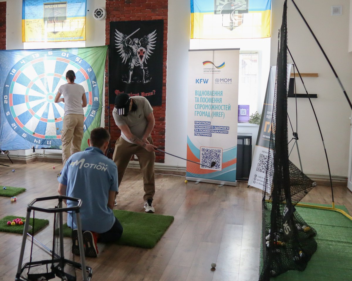 IOMUkraine's tweet photo. Thanks to @BMZ_Bund @KfW_FZ_int, IOM is organizing MHPSS adaptive golf sessions for 🇺🇦 veterans and their families. Led by an MHPSS specialist, the activity helps veterans, including those with disabilities, regain confidence, reconnect with others &amp; improve emotional well-being. https://t.co/ilrzOl9UH0