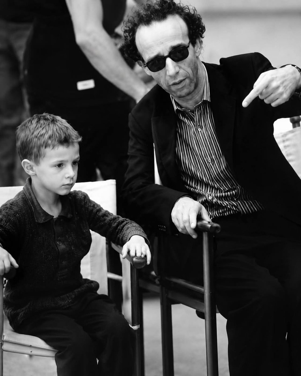 CrazyVibes_1's tweet photo. The five-year-old actor thought he was playing a game. He had no idea he was filming one of the most heartbreaking Holocaust stories ever told. His director made sure of it.
In 1996, Roberto Benigni faced an impossible challenge: how do you direct a film about the Holocaust that includes a young child without traumatizing that child?
"Life Is Beautiful" told the story of Guido, a Jewish Italian father who uses imagination and humor to shield his young son from the horrors of a Nazi concentration camp. The father pretends the camp is an elaborate game where they must follow rules to win a prize—a tank.
It's one of cinema's most devastating stories, wrapped in moments of unexpected laughter and fierce love.
But Benigni had cast five-year-old Giorgio Cantarini to play Giosué, Guido's son. And Giorgio was actually five—old enough to be affected by what he saw and heard, young enough to not fully understand context.
Benigni made a decision: Giorgio would never know the tragedy he was part of.
On set, Benigni turned filming into exactly what Guido does in the movie—he made it a game.
Even when they were shooting scenes inside the concentration camp set, with barracks and guards and the visual markers of genocide all around them, Benigni kept the atmosphere playful. He directed Giorgio with joy, with games, with laughter.
Between takes, he played with the boy. He made funny faces. He kept Giorgio focused on the immediate, simple tasks of acting—hit this mark, say this line, react to this moment—without ever explaining the larger, darker context.
To Giorgio Cantarini, the entire experience felt like make-believe. Which is exactly what it should have felt like to a five-year-old.
He didn't understand that the striped uniforms represented real prisoners. He didn't know what the showers meant. He didn't grasp that the "game" his character's father invented was a desperate lie to protect a child from understanding his own impending death.
He just knew he was making a movie with a funny, kind man who made everyone laugh.
It was the same devotion Benigni brought to Guido—a father who shields his child from horror by transforming reality into fantasy, who turns genocide into a game of points and prizes, who makes his son believe that silence during roll call and hiding in a box are just challenges to overcome for a reward.
The parallel wasn't accidental. Benigni understood that protecting Giorgio mirrored protecting Giosué. Both required creating an alternate reality where a child could exist without fear.
But there was another layer of love woven through the film.
Nicoletta Braschi, who played Dora—the mother who voluntarily boards the train to the concentration camp to stay with her family—is Benigni's wife in real life.
They met in 1980 and married in 1991. By the time they made "Life Is Beautiful," they had been artistic and romantic partners for nearly two decades.
The scenes between Guido and Dora aren't just good acting. They're built on years of real partnership, real love, real understanding.
When Dora looks at Guido in the film, Nicoletta is looking at Roberto. When Guido performs absurd acts of devotion to win Dora's heart, it echoes the playful, passionate relationship Benigni and Braschi have maintained throughout their marriage.
The scene where Guido orchestrates an elaborate encounter at the opera, where he pretends the orchestra is playing just for Dora, carries the weight of real romance behind the performance.
And the scene where Dora boards the train—knowing exactly where it's going, choosing to go anyway because she won't let her family face it alone—is acted by a woman who genuinely loves the man playing opposite her.
That authenticity radiates through the screen.
"Life Is Beautiful" premiered at Cannes in 1997 and became a phenomenon. It won the Grand Prix at Cannes, then three Academy Awards including Best Actor for Benigni, who famously climbed over seats at the Oscars in pure joy.
Critics debated whether comedy and the Holocaust could coexist. Some argued the film trivialized tragedy. Others saw it as a profound meditation on love, sacrifice, and the power of imagination to preserve humanity in inhuman circumstances.
But what endures about "Life Is Beautiful" isn't the debate—it's the emotion.
The film works because it understands something essential: love is an act of protection. Parents protect children. Partners protect each other. And sometimes protection means creating beautiful lies so that hope can survive a little longer.
Guido doesn't save his son's life by telling him the truth. He saves his son's spirit by transforming horror into a story a child can survive inside.
And Benigni didn't make a great film by forcing a five-year-old to understand genocide. He made a great film by protecting Giorgio the same way Guido protects Giosué—by letting him believe in games, in play, in joy, even when surrounded by the architecture of death.
Years later, Giorgio Cantarini grew up and understood what the film was really about. He watched it as an adult and finally grasped the story he'd been part of as a child.
In interviews, he's spoken about his gratitude for how Benigni handled the filming. He got to be part of an important, powerful film without being traumatized by it. He got to play, to laugh, to enjoy the experience—and only later, when he was old enough, did he fully comprehend its weight.
That's the gift Benigni gave him. The same gift Guido gives Giosué in the film.
"Life Is Beautiful" asks an impossible question: How do you preserve innocence in the face of absolute evil?
And it answers with love. With creativity. With the fierce determination to protect what matters most, even if it means lying, even if it means playing games in the shadow of death.
Roberto Benigni created a film about a father who shields his child through imagination.
And then he shielded his young actor the exact same way.
On screen and off screen, the story was the same: love means protection. And sometimes protection means creating a beautiful version of reality that lets hope survive just a little longer.
Giorgio Cantarini played a game on set.
Giosué believed his father's game in the camp.
Both children were protected by men who understood that preserving a child's spirit is worth any lie, any performance, any sacrifice.
That's what makes "Life Is Beautiful" endure.
Not just its heartbreaking story, but the love, protection, and tenderness that shaped it—in the script, in the performances, in how it was made.
Roberto Benigni and Nicoletta Braschi built a film together out of real partnership and real love.
And they protected a five-year-old boy from understanding tragedy until he was old enough to handle it.
That's not just good filmmaking.
That's humanity at its finest