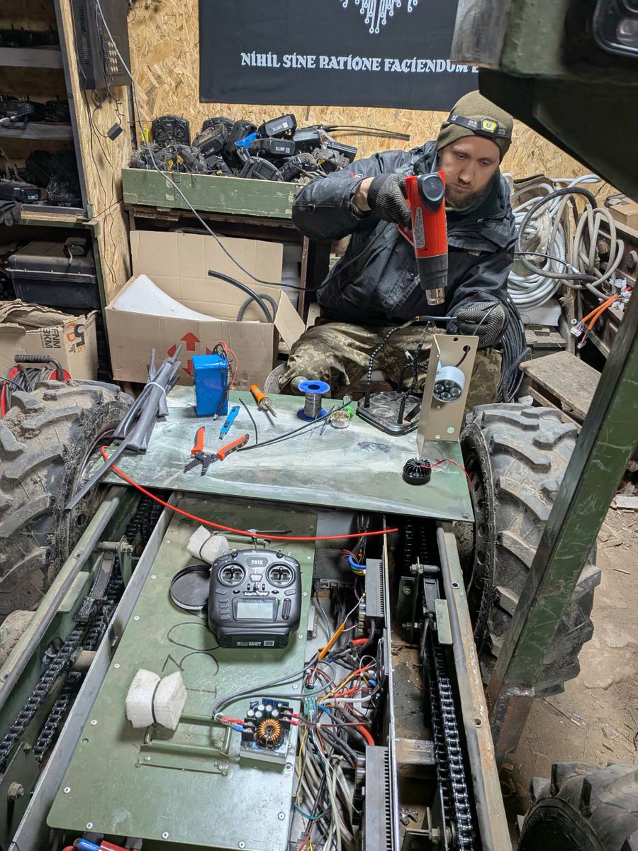 JBpress's tweet photo. 補給、救出、そして攻撃…これがウクライナ前線を支える「陸上ドローン」運用部隊だ、日本人記者が現場に密着《谷川 ひとみ》@thitomin 
陸上ドローンの存在自体は2024年から聞いていたし、映像も見たことがあった。ただ、周囲の兵士に聞いても実際に使った、ないし任務の現場で見たという話は聞いたことはなく、「兵士の代わりに物資を運ぶ」くらいのイメージしかなかった。
部隊への取材前に案内してくれる友人に陸上ドローンについて少し教えてもらう。
陸上ドローンはこれまでは主に負傷兵の救助に使用されていた。兵士には危険すぎて行くのが難しい地域にも陸上ドローンなら行けるからだ。
しかし、最近では機関銃などを設置して攻撃にも使われている。驚いたことに陸上ドローンを使って戦車を破壊することもできるという。
「自分たちは陸上ドローンのカスタマイズを先駆けて積極的に行っている。ここで、カスタマイズされ、実戦投入して効果が確認できたものが他の部隊で使用される」
部隊の基地に着き、簡単な説明をお願いすると、隊員は胸を張ってそう答える。なるほど、陸上ドローンの運用実験を行う、いわば精鋭部隊なわけだ。
▶続きを読む（コメント欄へ）