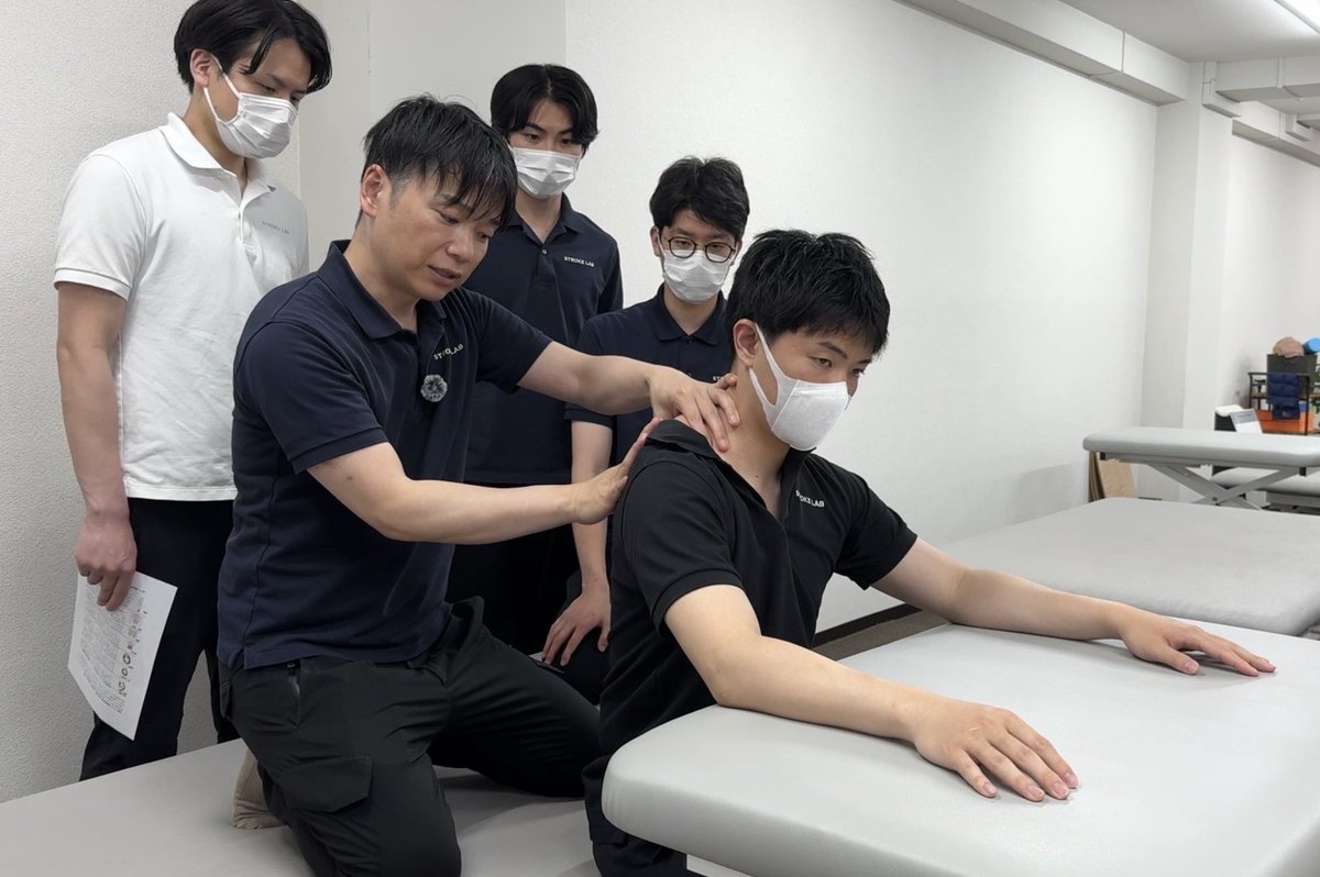 thinkable77's tweet photo. 【週1回・少人数制スタッフ実技】
週1回の実技を中心とした少人数制のスタッフ勉強会を実施しました。
今回のテーマは、「頭頸部の側屈と回旋における運動連鎖」についてです。
下肢・体幹に比べて、頭頸部を触り慣れていないセラピストが多く、適切なハンドリングが難しい部位でもあります。 頭頸部を回旋した際、その動きに伴って同側への側屈が起こりやすくなります。さらに運動連鎖として、回旋側の肩甲骨は前方に移動し、胸郭も引き込まれ、骨盤にまで動きが波及していきます。
しかし、脳卒中片麻痺の方の場合、この連鎖が過剰な代償パターンとして現れることが多くあります。
例えば、頭頸部の動きに伴って麻痺側の肩甲骨が過剰に挙上・前傾し、胸郭が下がり、それが体幹の過剰な側屈に繋がっているケースです。
今回の実技では、こうした過剰な運動連鎖を外していくアプローチを深掘りしました。
具体的には、僧帽筋上部や肩甲挙筋から前方/後方への回旋を引き出し、まずは肩鎖関節の分離を促していきました。
臨床で多く見られるのは、大胸筋から肩甲骨を下方向に誘導後、すぐに肩甲胸郭関節へと移ってしまうパターンです。
しかし、土台が不安定な状態で動きを強要すると、関節への過剰な負担に繋がってしまいます。
そして実技を通して改めて確認したのは、ただ対象の筋肉をハンドリングすれば良いわけではないということです。
例えば姿勢が右に崩れている方に対しては、反対の手でしっかりと正中位へコントロールしながら介入するなど、対象者の全身の姿勢制御を伴わなければ、頭頸部の適切な分離を引き出すことはできません。
日々の臨床や自身のトレーニングを通して、頭頸部の感覚を積み重ねていくことが重要です。 頭頸部の筋を適切にコントロールできることが、結果的に下肢や骨盤など、他の部位への正確なアプローチにも繋がっていくことを、改めて共有できました。