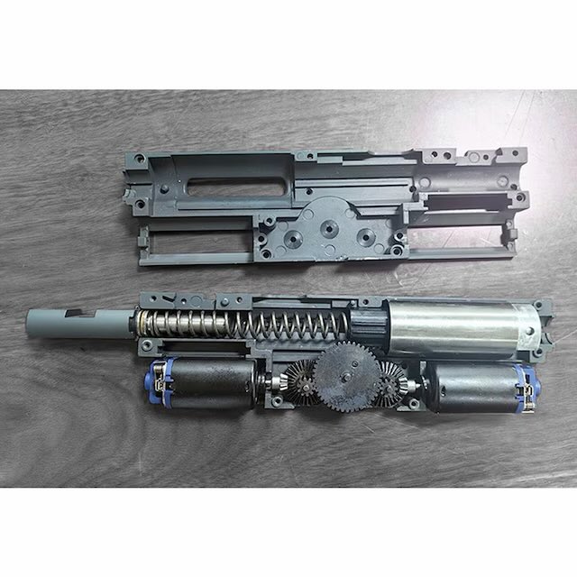 yousunics's tweet photo. WELL M249ミニミ ツインモーター
EG1000系モーターを2機搭載、ベベルギアからセクターギアの大型スパー部に直結で繋がるシンプルな駆動系＝電動ガンで弱いとされるスパーギアの排除となり、駆動効率アップと故障率低下が期待されます
フロントサイトなどのメタルパーツは亜鉛ダイキャストではなくアルミダイキャスト？でかなり軽い仕上がりでメカボはQD！