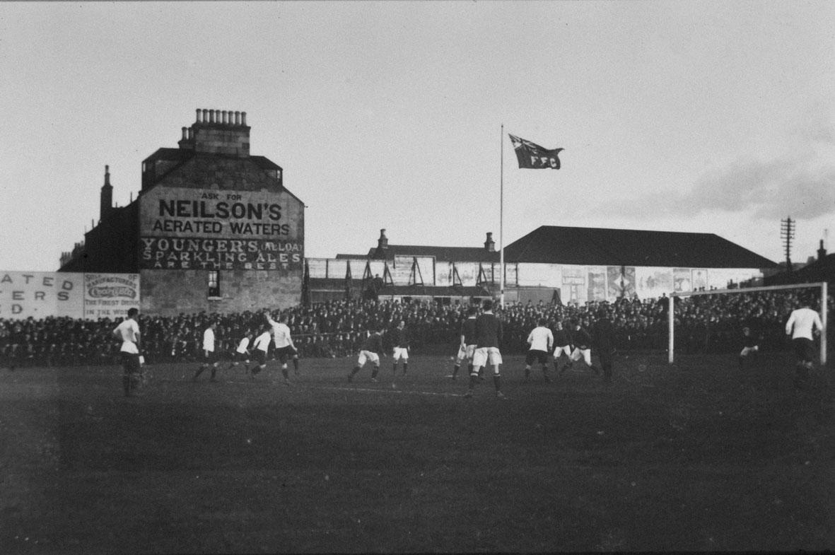 footyheritage's tweet photo. Falkirk FC playing at a packed Brockville Park, c. 1905.

Photographed by Thomas Easton, with the Falkirk FC flag flying, you can see tenement-side adverts in the background.

Coca Cola, Neilson's Aerated Waters and local sparkling ale brewer Younger's of Alloa all represented.

Photo Credit: Falkirk Council Collections