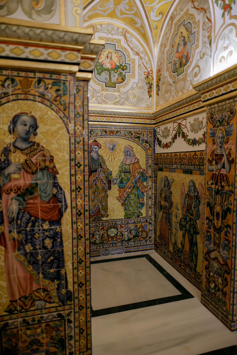 EspDeTriana's tweet photo. 💚 #PATRIMONIO | El camarín de Nuestra Señora de la Esperanza: El Arte Sacro sevillano al servicio de la Santísima Virgen 

Los espacios laterales o ante camarines están decorados con dibujos ornamentales que imitan yeserías, tanto en las paredes como en las bóvedas, presididos por medallones en los que figuran Letanías de la Santísima Virgen, mientras que los arcos se decoran con yeserías y racimos de flores y frutas sujetados por lazos. Cada Letanía, aprobadas oficialmente por el Papa Sixto V en 1587, aunque se venían rezando desde mucho tiempo antes, está representada por una figura de Nuestra Señora rodeada de símbolos alegóricos provenientes del Renacimiento y el Barroco. Las alabanzas a Dios o letanía representadas en la pintura mural son: Madre Castísima, Auxilio de los Cristianos, Torre de David y Rosa Mística, Madre de la Divina Gracia, Virgen Poderosa y Puerta del Cielo.

Los paramentos situados por encima de los zócalos cerámicos de los ante camarines, que representan coros de ángeles músicos, se han decorado con guirnaldas de flores y frutas sujetas por lazos y entre las guirnaldas aparecen ocho cartelas con los nombres de algunas  mujeres fuertes de la Biblia: Judith, Esther, Rut, Miriam, Débora, Sara, Rebeca y Jael.
 
Por último, culminando el discurso de alabanza a la Santísima Virgen, en la entrada del camarín se sitúa una cartela que el fiel verá a su salida donde se lee en latín la frase “Bienaventurada me llamarán todas las generaciones”, también extraída de la oración del Magníficat, una de las más antiguas del cristianismo tomada directamente del Evangelio de San Lucas, que pronunció la propia Virgen María durante su visita a su prima Santa Isabel. Todas las pinturas se han realizado con técnicas al óleo y pan de oro.

#EsperanzaDeTriana