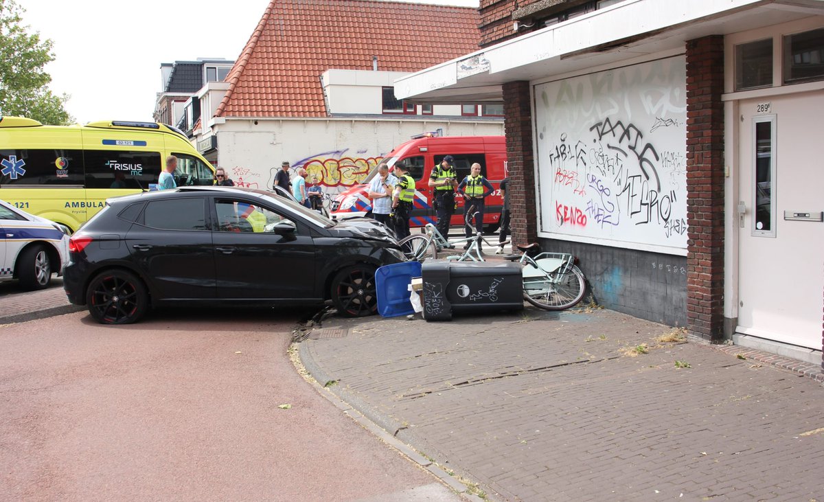 Auto ramt gevel gebouw bij drukke rotonde in Leeuwarden; een gewonde