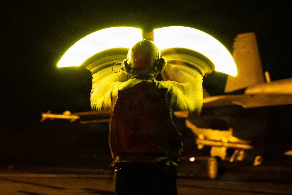 CENTCOM's tweet photo. U.S. Sailors conduct night flight operations aboard USS George H.W. Bush (CVN 77). At night, highly skilled pilots are able to land on a small deck that is both pitching and rolling in near-total darkness. https://t.co/R6XKjjc8M4