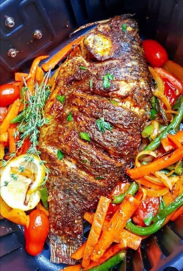 NThanh86518's tweet photo. Tilapia is marinated with olive oil, thyme and minced garlic, then air-fried with shredded carrots, bell peppers, green beans and cherry tomatoes. The fish is golden and crispy outside while staying moist inside. Finished with lemon and thyme for a fresh, light flavor!  
  👉  #Tilapia 
          #AirFryer
          #HealthyDinner
          #FishRecipe