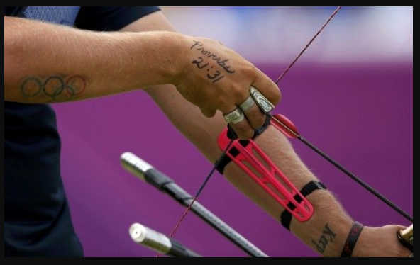 morme1's tweet photo. Brady Ellison: 
His tattoos are reminders too...... 
Key Awards and Achievements

Olympic Medals: Silver (2012 London team, 2016 Rio team), Bronze (2016 Rio individual, 2024 Paris individual), and Bronze (2024 Paris mixed team)

World Archery Championships: Champion in 2019, the only male to win six Archery World Cup Finals World Archery.

World Indoor Championships: Two-time gold medalist (2012, 2014) 

World Archery Field Championships: Three-time gold medalist, most recently in 2024 World Archery.

Archery World Cup Finals: Six-time winner, including a dominant 2019 season where he set a world record of 702 points in the ranking round World Archery.

Pan American Games: Gold (2011 individual, 2019 mixed team), Silver (2011 team), Bronze (2019 team) Wikipedia.

World Archery Rankings: First American to hold the world number one spot (2011–2013), and he reclaimed it in 2025 after 15 years USA Archery.