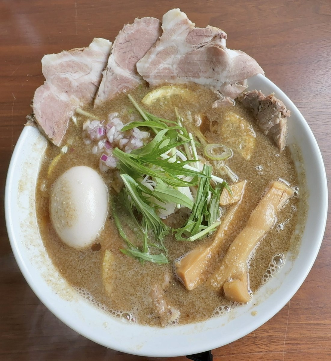 kakusankibouRT's tweet photo. 今日は由利本荘市の【麺屋Sasaki】に行って来ました🚗☁️（初来店！）

去年火事で一時休店してた麺屋Sasakiが移店オープンしました㊗️🎉

移転先は西目方面で国道からちょっと海側に入ったちょっと目立たない場所。
ただ、場所がわかれば全然行きやすい場所。

店の入り口には入り口とお会計と書かれてるが、入り口から入って帰りにお会計のドアから入って会計する形。

店内はどこかノスタルジックな雰囲気でテーブル席が何席かあってカウンター席はない？いやある？感じ（どんな感じだ😅）（1人席のテーブル席がある）

注文はお店の人がとりに来る。
注文は背油にぼし中華そば（大盛り）TPチャーシュー❗️

1人席のテーブルで待ってると間もなく着丼❗️

スゴくキレイな丼顔❗️
これは絶対旨いやつ🍜

スープは煮干しが強く出てて煮干しの旨味に醤油タレがガツンと来る一杯！
煮干しのクドさは勿論なくて結構醤油の旨味を感じるあっさりスープ🍜（濃厚ではない）

そしてレモンが入ってるのも特徴的で、煮干し醤油スープにレモンの爽やかな酸味がスゴく良いアクセントになってて、特に後半はレモンの爽やかな酸味がスゴく良くて結構スープ飲んじゃいました🍜

麺は多加水中太縮れ麺で食べ応えあるモチモチ麺で自分好み😋
最近のお店、中太縮れ麺増えてきてボック大満足😆
どうしても秋田県は細麺が多いからなあ。

因みにラーメンによっては細麺もあるようだ。多分、親鶏中華とかは細麺なのかな？

まだ移店開店したばかりでオペレーションが不慣れな雰囲気とかあるけど、応援してます！

あと出来れば個人的にはやはりカウンター席と券売機があれば良いなと思いました。
あと試作で作ってたまぜそば、是非食いたいデス！（まぜそばは若者にも人気だからメニューにあれば良い気がします）

ご馳走様でした😋
旨かったデス！🍜