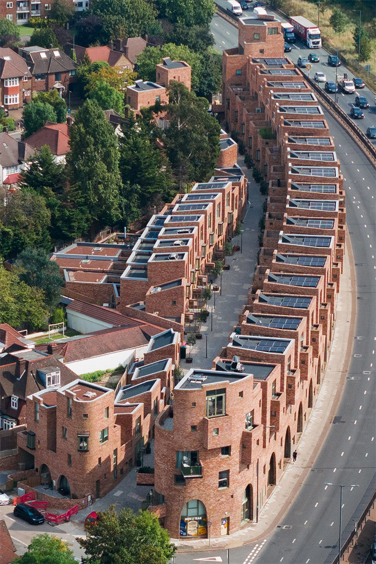 archpng's tweet photo. On a long-vacant strip beside London’s North Circular Road, Peter Barber Architects created Edgewood Mews: 97 homes arranged around a car-free, double-crescent pedestrian street.

Formerly known as Beechwood Mews, the project includes 50% affordable housing, plus a café and corner shop — turning a difficult roadside site in North London into a compact piece of city-making.

Architect: @ peterbarberarchitects