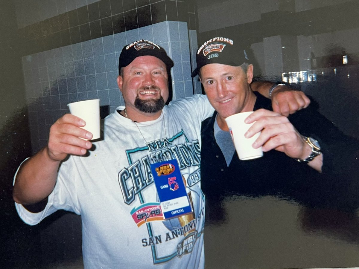 EdCosner's tweet photo. Brungy and me celebrating and about to drink a lot of beer!!!

Spurs v Knicks - locker room celebration after the 
SPURS won in 5 games to become 1999 NBA Champions

We came in healthy and strong having only dropped 1 game to the Timberwolves in the first round then we swept BOTH the Lakers and then the Trailblazers on our way to win the Western Conference Championship!!! 

The Knicks came to town and we won both Games 1 and 2 in the Alamodome which was ROCKING!!! It was so loud in there and so exciting to be a part of sitting behind the bench!! 
I can still remember on my drive into downtown in my Jeep (no doors or top) and people recognizing me!! They’d pull up next to me cheering and hitting the horn as we drove down 281!! 
Then you’d get near the Alamodome and you’d see huge signs hanging from buildings GO SPURS GO!! Everyone in San Antonio felt part of the team and they were!! 

Stay tuned because next I’ll share Games 3,4, & 5 out in NYC and some of the wild shit that could only happen to me!!!

#powersportstrengthconditioning #oldstrongguysrule #spurs