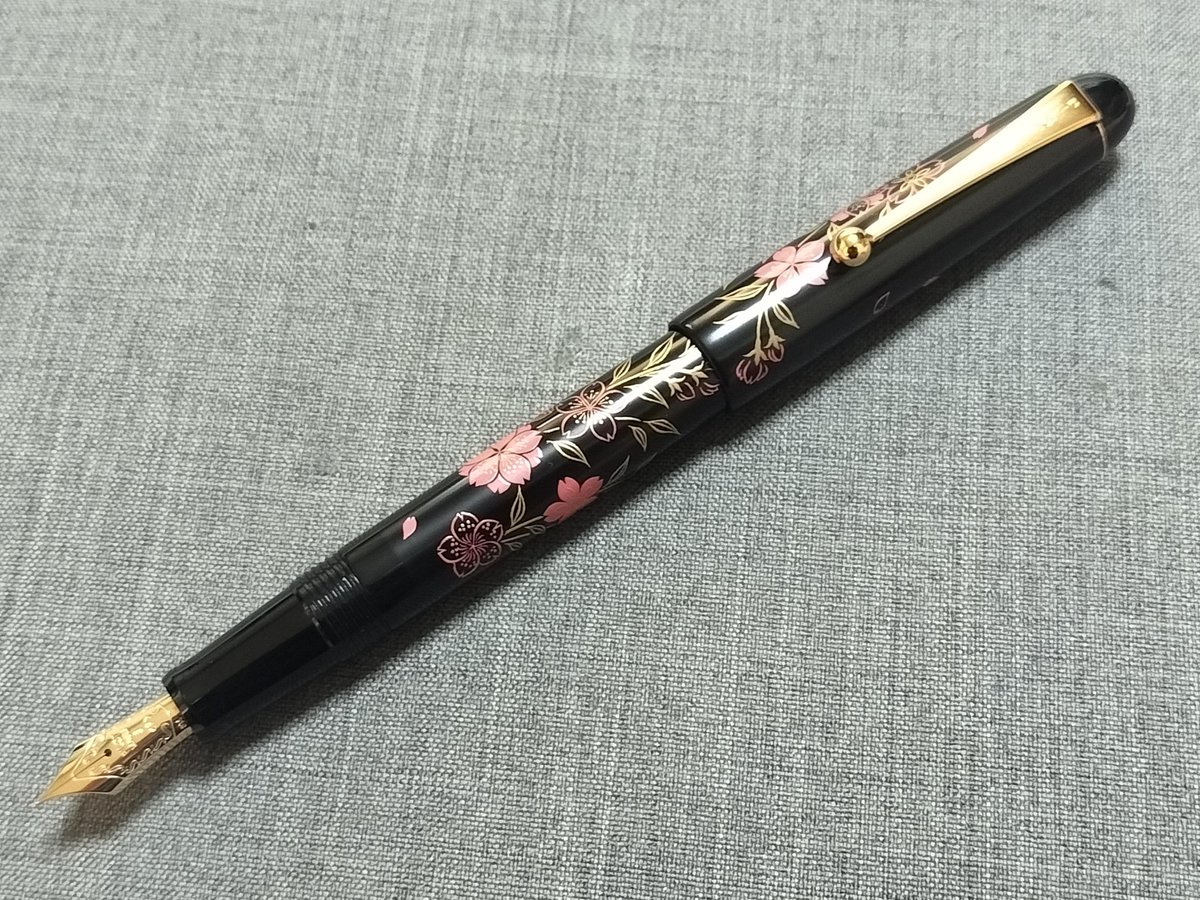dome_fp's tweet photo. 今日のペンはパイロット 平蒔絵 桜【FK-5MP-SKU】です。すでに製造中止になったパイロット名義で30,000円＋税の廉価版蒔絵シリーズです。まだ残っているんですねぇ…

胴軸からリング無しのキャップにかけて桜の図柄の蒔絵が施されています。ペン先はカスタム74と同じ14金5号が与えられています。 https://t.co/Mpv0FwB4Wf