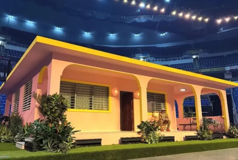 Juangayasalom's tweet photo. A la izquierda tenemos la casa de Román Carrasco, una humilde vivienda ubicada en el Barrio Río Abajo en Humacao donde se grabó el cortometraje “Debí Tirar Más Fotos” y que se ha convertido en el decorado habitual de los conciertos de Bad Bunny (foto a la derecha). 

La foto de la izquierda representa valores férreos, humildad, lucha y tradiciones puertoriqueñas. La imagen de la derecha representa clasismo, postureo, infamia, obscenidad y vergüenza. 

Por cierto, el dueño de la casa original presentó una demanda contra el artista y sus productores alegando enriquecimiento injusto. La acción civil, radicada ante el Tribunal de San Juan, reclama $1 millón por daños y angustias, y $5 millones adicionales por el uso de la propiedad y enriquecimiento ilícito.

Benito hueles a esmegma y a sobaco